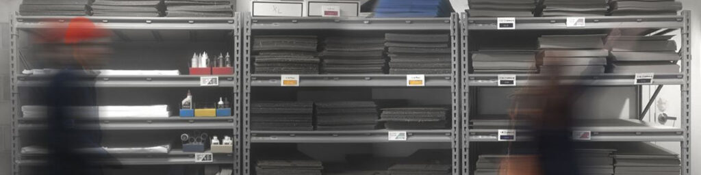 Illustrated photo of products on shelves of the Lab Store, L45 of Gund Hall. Blurry figures are in front of the shelving.